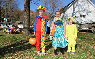 Three children dressed in colorful costume at Ushers Ferry